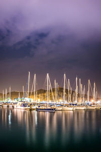 Sailboats moored in sea against sky