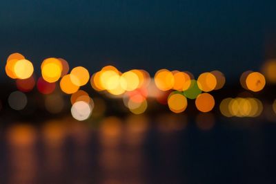 Defocused lights against sky at night