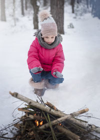 Child in winter. little girl in winter in nature warms her hands by the fire