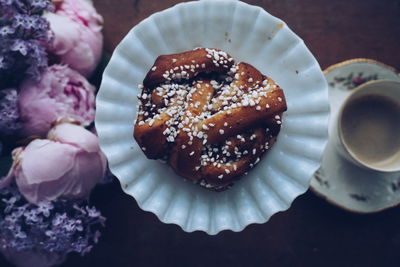 Directly above shot of cinnamon rolls with coffee by peony on table