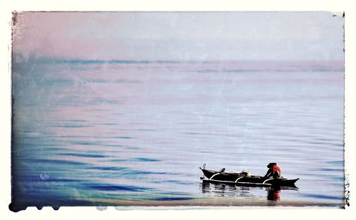 Rear view of woman sitting in water