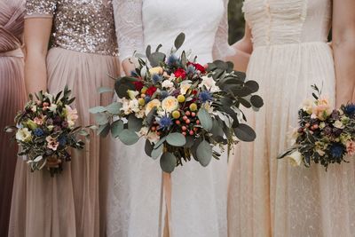 Bride and bridesmaids holding wedding flower bouquete in dress