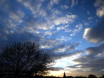 Low angle view of silhouette trees against dramatic sky