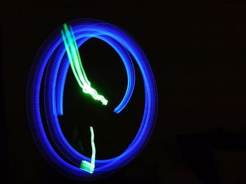 Close-up of illuminated lighting painting against black background