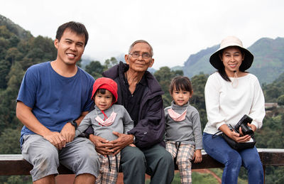 An asian family happily photographed together in a tea plantation.
