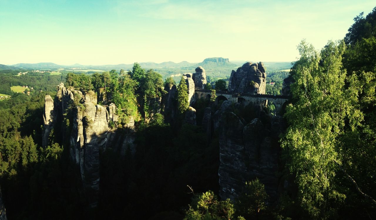 mountain, tree, tranquility, tranquil scene, sky, scenics, nature, beauty in nature, landscape, rock - object, mountain range, growth, green color, non-urban scene, idyllic, day, rock formation, built structure, outdoors, remote