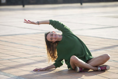 Low section of woman sitting on street