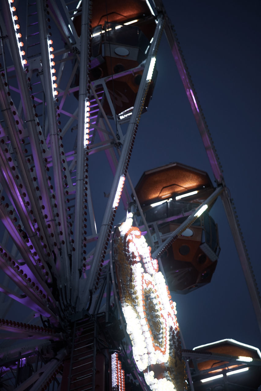 LOW ANGLE VIEW OF ILLUMINATED FERRIS WHEEL IN CITY