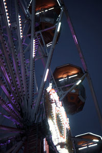 Low angle view of illuminated ferris wheel against sky at night