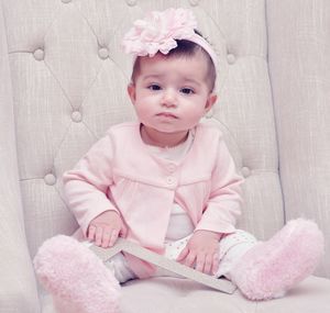 Portrait of cute baby girl sitting on armchair