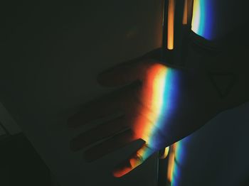 Person hand on illuminated wall