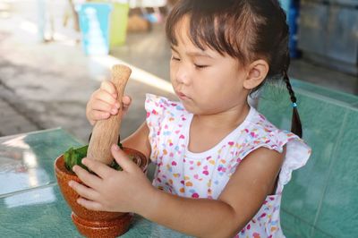 Cute girl preparing food in mortar and pestle