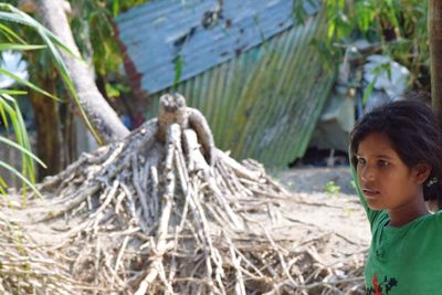 Girl looking away by trees in village