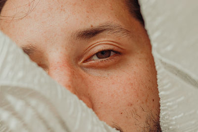 Close-up portrait of a man lying on bed