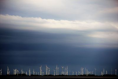 Panoramic view of wind turbines against sky