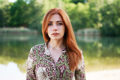 Cool young woman floral pattern ummer dress standing by lake