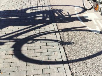 High angle view of bicycle shadow on cobblestone