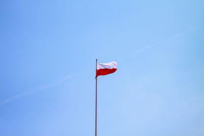 Low angle view of flag against clear blue sky