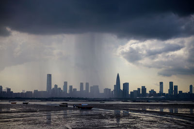 View of buildings in city against cloudy sky