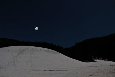 Scenic view of snow covered land against sky at night