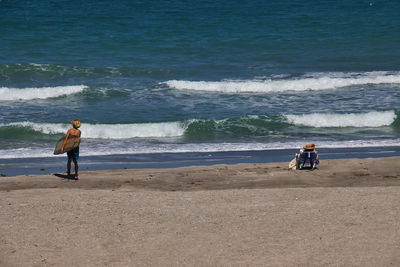 Rear view of men standing on beach