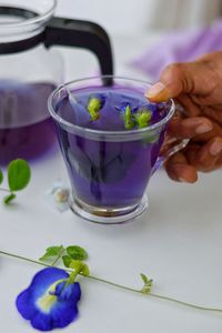 Midsection of person holding drink on table