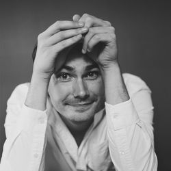 Portrait of man making face against black background