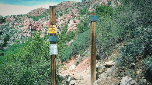 Information sign on wooden post on land