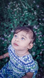 Close-up of cute girl sitting amidst plants