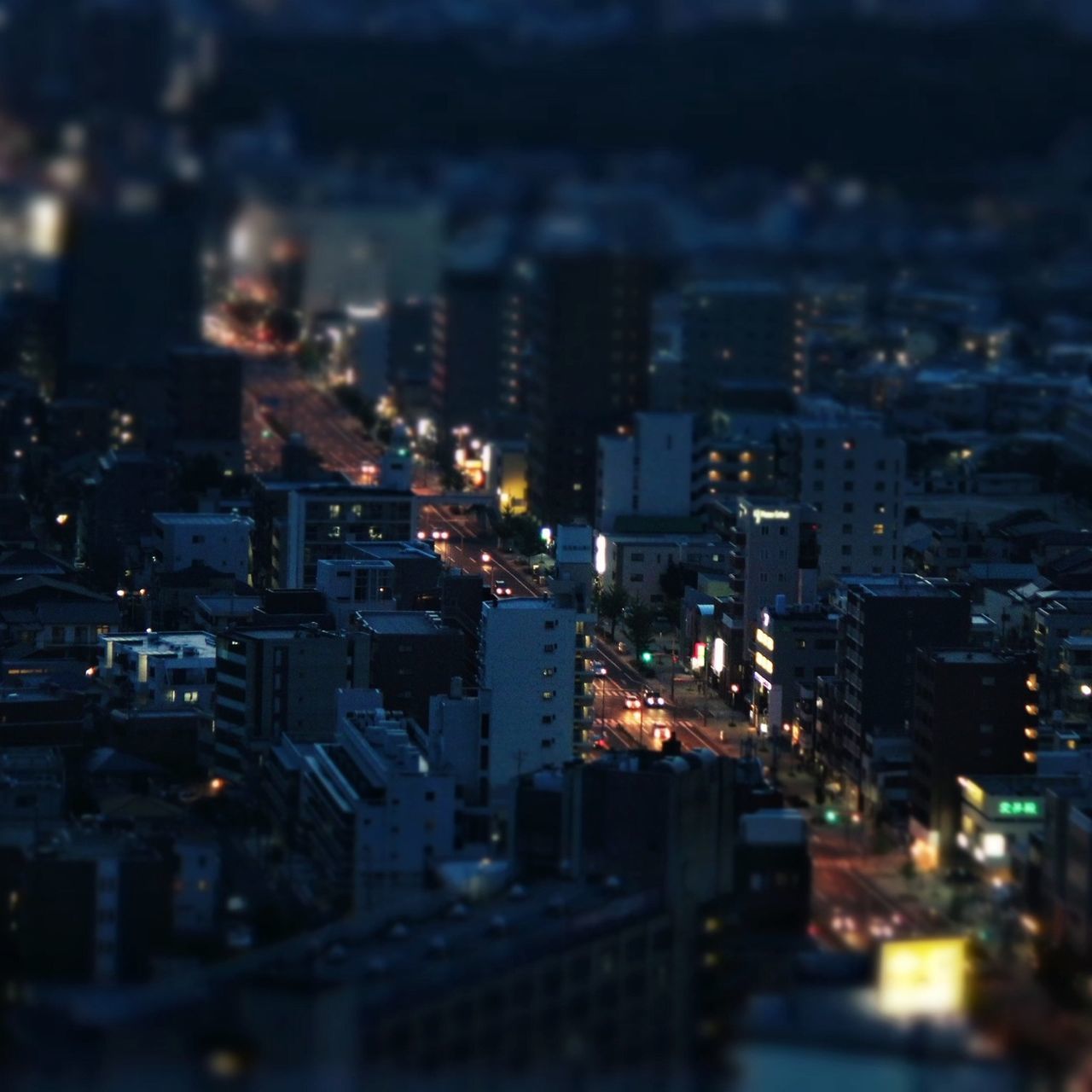 illuminated, city, building exterior, night, architecture, cityscape, built structure, crowded, high angle view, city life, selective focus, defocused, residential building, no people, skyscraper, residential structure, outdoors, street, road, residential district