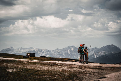 People standing on mountain against sky