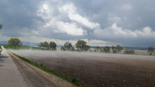 Empty road against cloudy sky