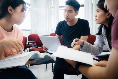 Friends discussing while sitting in classroom