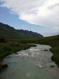 Scenic view of river and mountains against sky