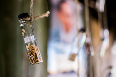 Close-up of seeds in plastic bottle hanging for sale at store