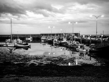 Sailboats moored at harbor