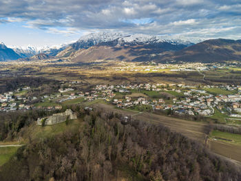 Aerial view of field by buildings against sky