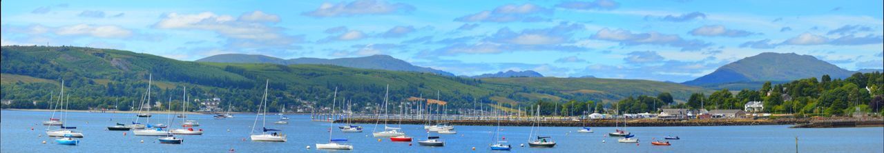 Panoramic view of boats in sea against mountains