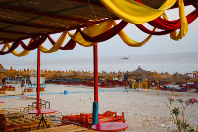 Deck chairs and parasols on beach against sky