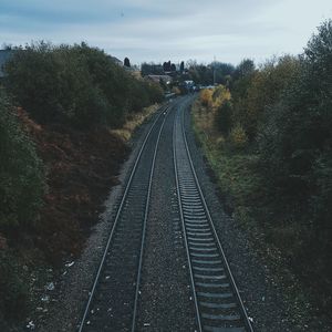 Railroad tracks amidst trees against sky