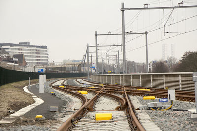 Railroad tracks in city against clear sky