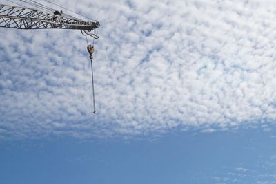 Low angle view of crane against sky during winter