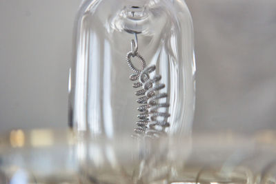 Close-up of spiral hanging on glass