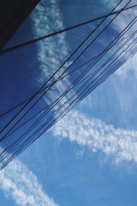 Low angle view of power lines against cloudy sky