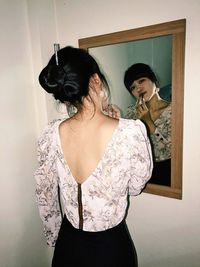 Portrait of woman doing makeup in front of mirror 