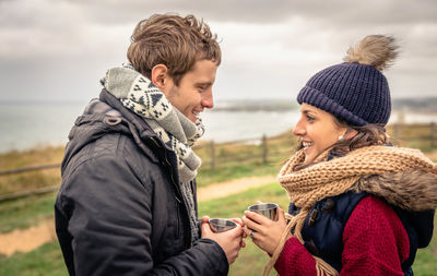 Young woman using phone while standing on land