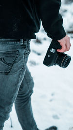 Low section of man standing in snow
