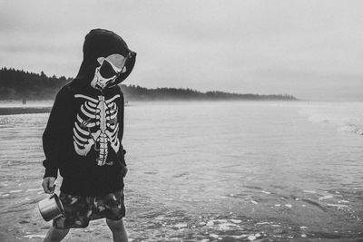 Full length of man standing by lake against sky