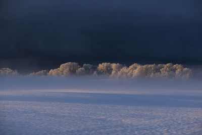 Scenic view of snow covered land against sky