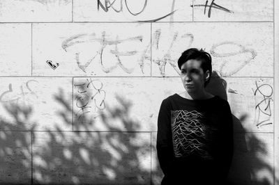 Full length of teenage boy standing against wall